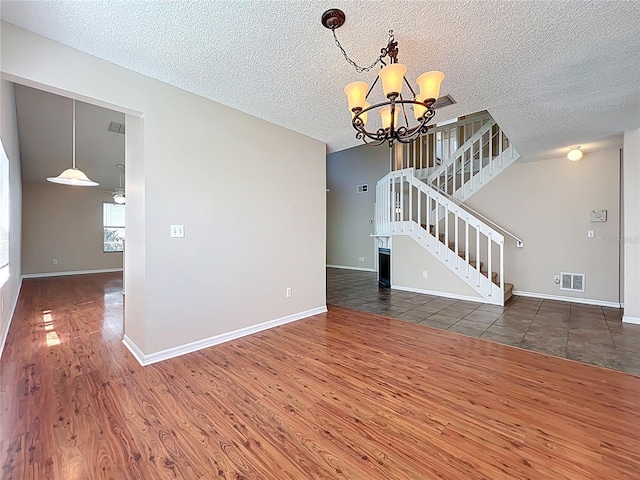 358 Morning Creek Cir, Apopka, FL 32712 - unfurnished living room featuring visible vents, baseboards, stairs, an inviting chandelier, and wood finished floors