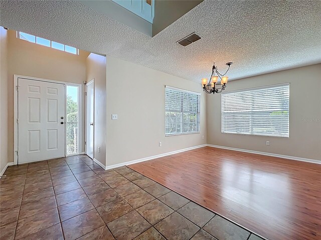 358 Morning Creek Cir, Apopka, FL 32712 - foyer with visible vents, a textured ceiling, tile patterned flooring, baseboards, and a chandelier