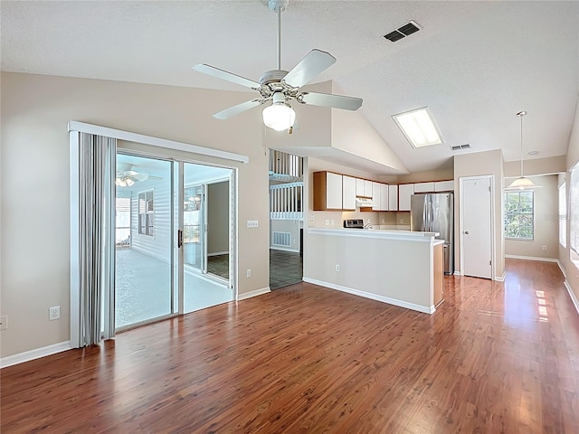 358 Morning Creek Cir, Apopka, FL 32712 - kitchen featuring visible vents, ceiling fan, a peninsula, freestanding refrigerator, and wood finished floors