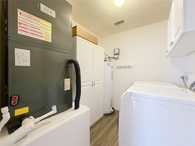 358 Morning Creek Cir, Apopka, FL 32712 - laundry room featuring light wood finished floors, visible vents, water heater, cabinet space, and separate washer and dryer