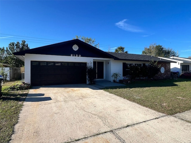 6130 Gamble Dr, Orlando, FL 32808 - ranch-style home with a garage, concrete driveway, a front yard, and stucco siding