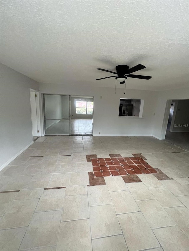 6130 Gamble Dr, Orlando, FL 32808 - unfurnished living room with baseboards, a textured ceiling, and a ceiling fan