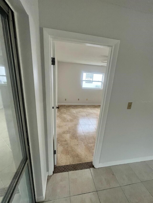 6130 Gamble Dr, Orlando, FL 32808 - hallway featuring light tile patterned floors and baseboards