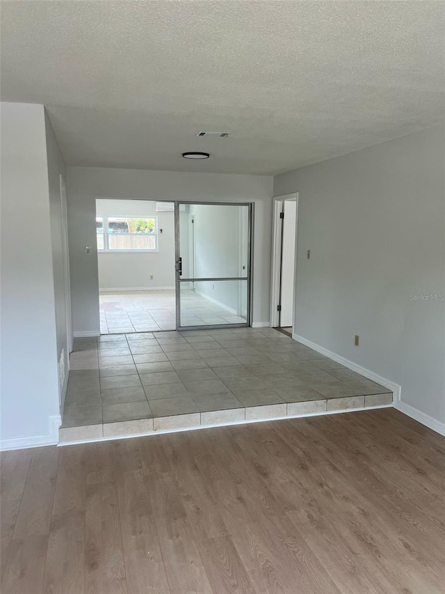 6130 Gamble Dr, Orlando, FL 32808 - spare room with visible vents, a textured ceiling, baseboards, and wood finished floors