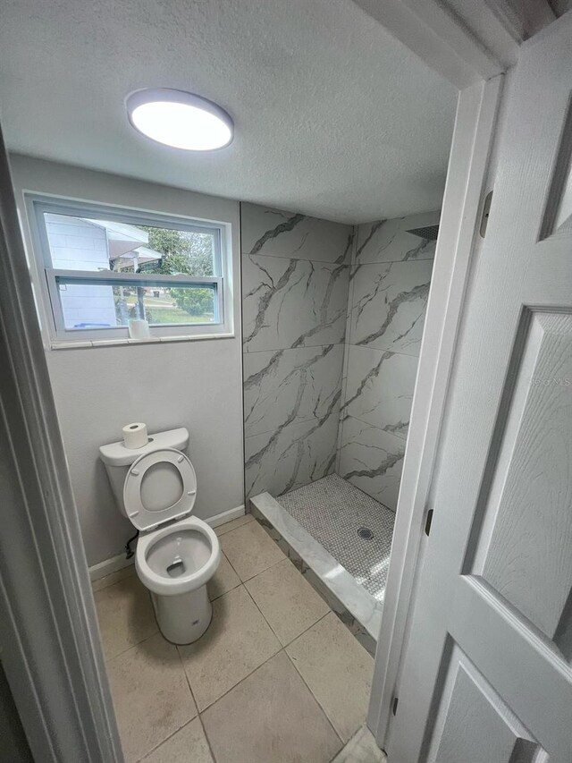 6130 Gamble Dr, Orlando, FL 32808 - full bathroom featuring baseboards, a shower stall, a textured ceiling, tile patterned floors, and toilet