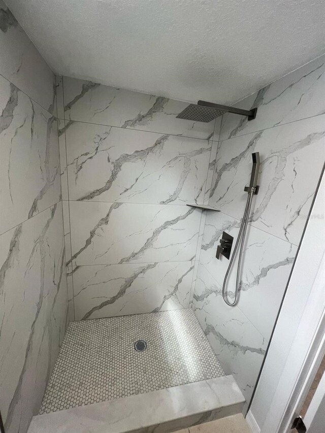6130 Gamble Dr, Orlando, FL 32808 - bathroom featuring a marble finish shower and a textured ceiling