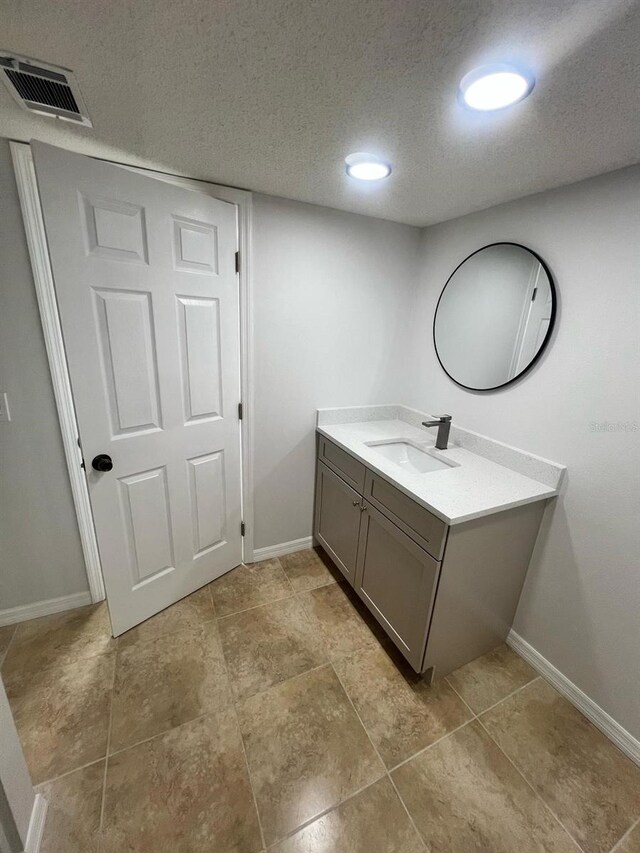 6130 Gamble Dr, Orlando, FL 32808 - bathroom with visible vents, a textured ceiling, vanity, and baseboards