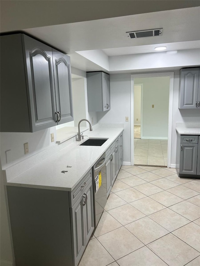 6130 Gamble Dr, Orlando, FL 32808 - kitchen featuring light tile patterned floors, visible vents, gray cabinets, a sink, and dishwasher