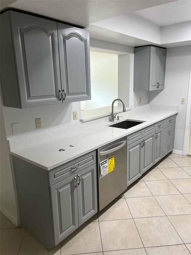 6130 Gamble Dr, Orlando, FL 32808 - kitchen with light tile patterned floors, a sink, gray cabinetry, and stainless steel dishwasher