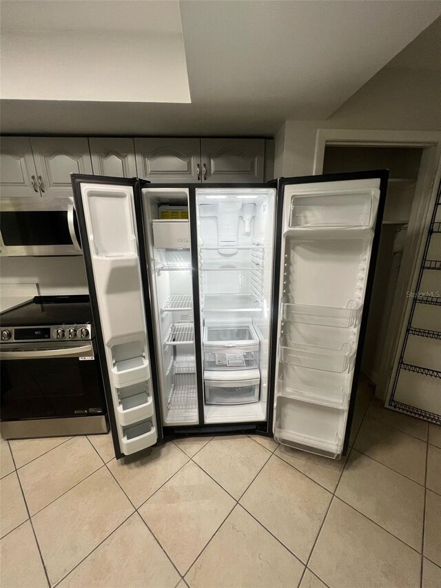 6130 Gamble Dr, Orlando, FL 32808 - interior space with light tile patterned floors and appliances with stainless steel finishes