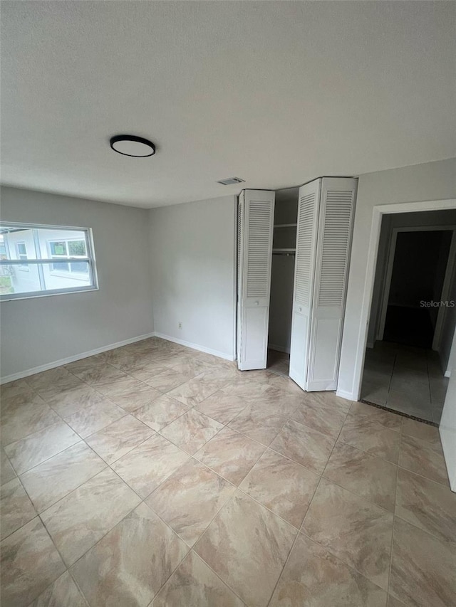 6130 Gamble Dr, Orlando, FL 32808 - unfurnished bedroom featuring a closet, visible vents, a textured ceiling, and baseboards