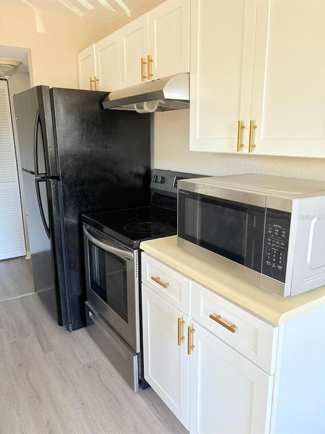 kitchen with under cabinet range hood, light wood-type flooring, white cabinetry, light countertops, and appliances with stainless steel finishes