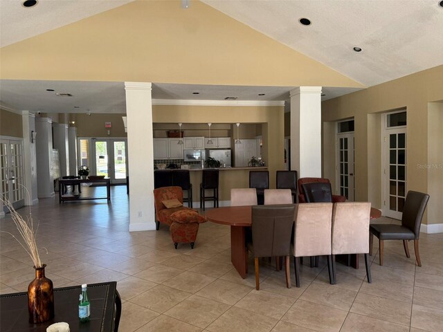 dining area featuring light tile patterned flooring, recessed lighting, vaulted ceiling, ornate columns, and french doors