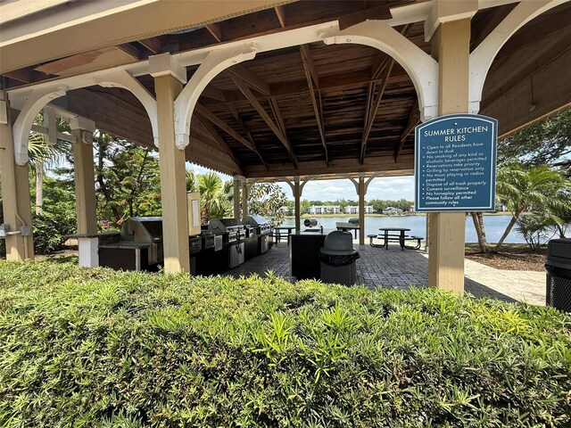 view of patio with a gazebo, area for grilling, and a water view