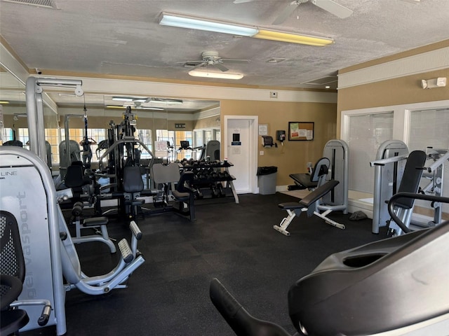 gym with a textured ceiling, ceiling fan, and visible vents