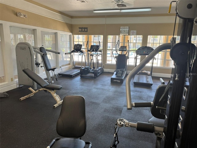 gym with baseboards, visible vents, and ceiling fan
