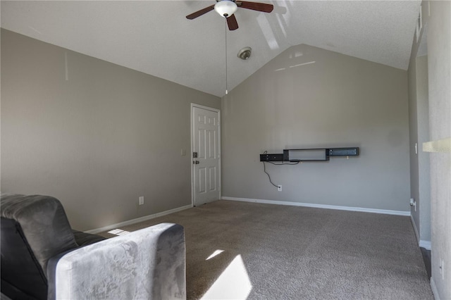 living area featuring baseboards, ceiling fan, carpet floors, and vaulted ceiling