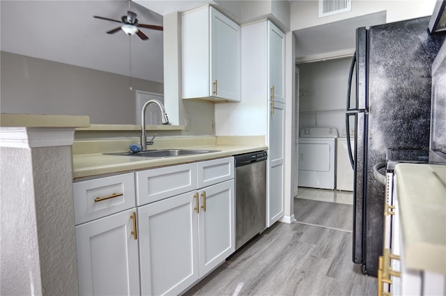 kitchen with light wood finished floors, a sink, visible vents, washer / clothes dryer, and dishwasher