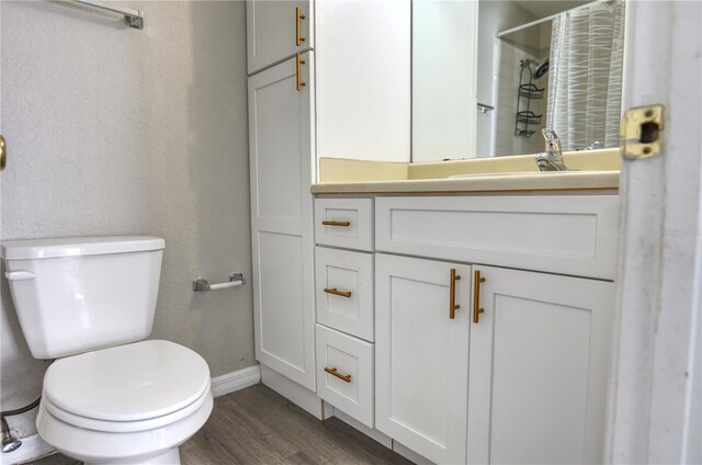 bathroom with a shower with curtain, vanity, toilet, and wood finished floors