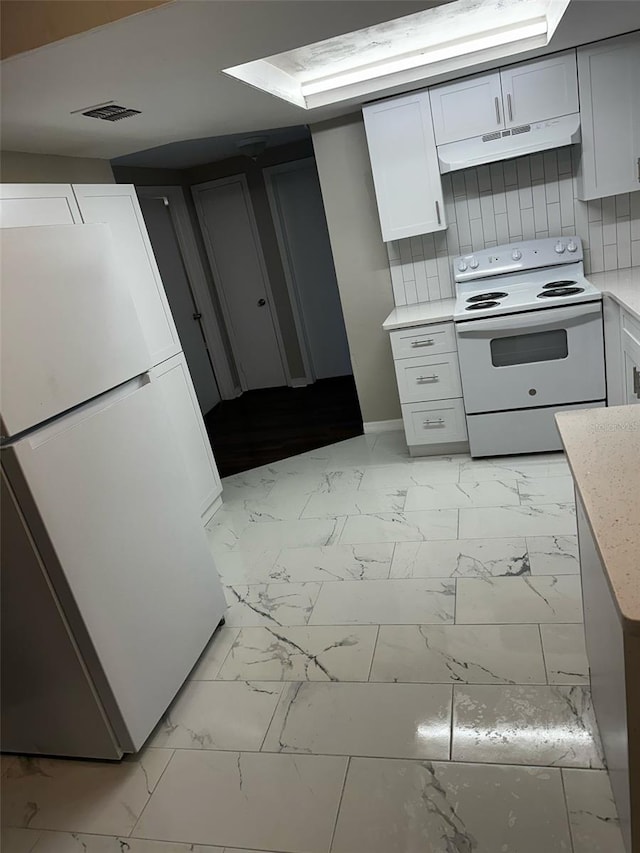 kitchen with under cabinet range hood, white appliances, tasteful backsplash, and marble finish floor