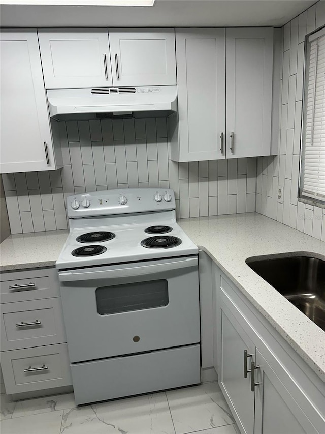 kitchen featuring under cabinet range hood, decorative backsplash, marble finish floor, and white electric range oven