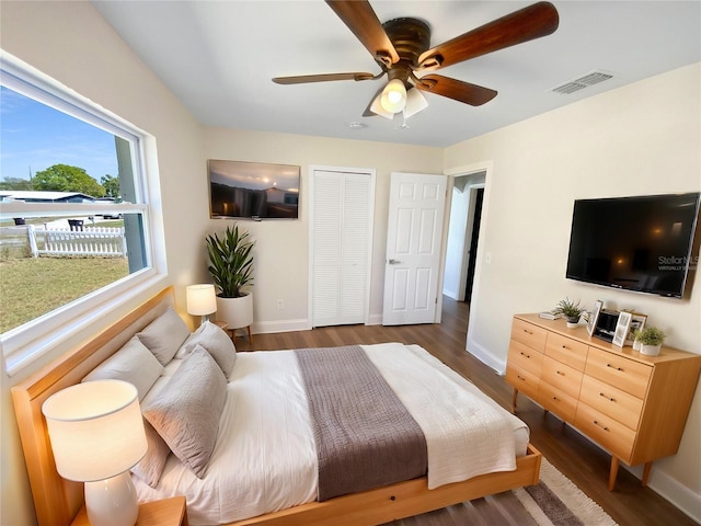bedroom with wood finished floors, baseboards, and visible vents