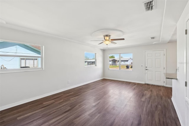 empty room featuring a ceiling fan, dark wood-style flooring, baseboards, and visible vents