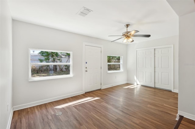 entrance foyer with baseboards, visible vents, wood finished floors, and ceiling fan