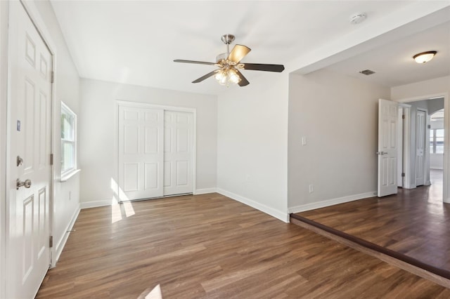 interior space featuring baseboards, wood finished floors, a closet, and a ceiling fan