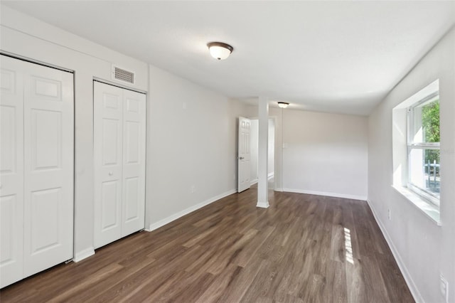 unfurnished bedroom with baseboards, visible vents, and wood finished floors