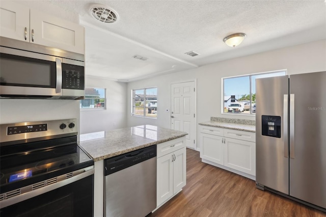 kitchen with white cabinetry, visible vents, wood finished floors, and appliances with stainless steel finishes