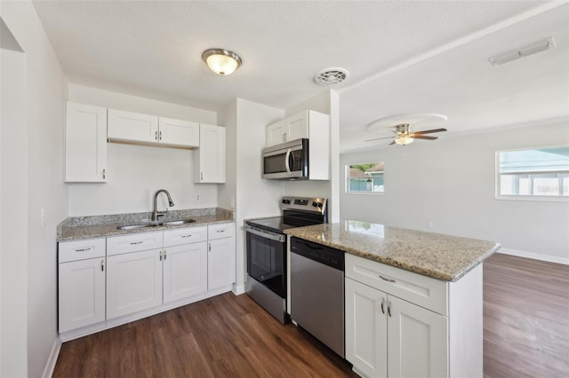 kitchen featuring visible vents, a sink, a peninsula, and appliances with stainless steel finishes