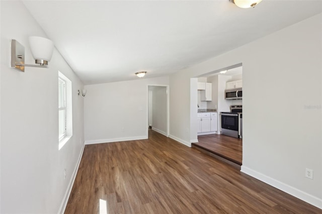unfurnished living room featuring dark wood-style floors and baseboards