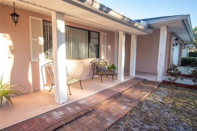 entrance to property with a porch and stucco siding