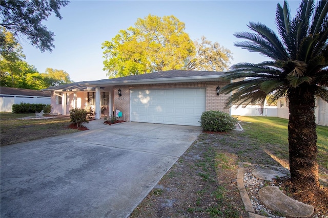 ranch-style house with a garage, brick siding, driveway, and a front lawn