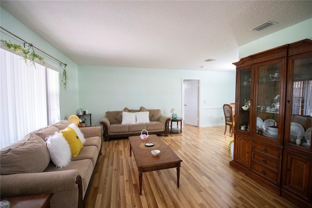 613 Andrew St, Altamonte Springs, FL 32714 - living area featuring light wood finished floors, a textured ceiling, and baseboards