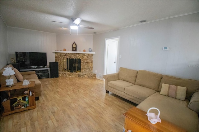 613 Andrew St, Altamonte Springs, FL 32714 - living area with crown molding, light wood-type flooring, a ceiling fan, and a stone fireplace