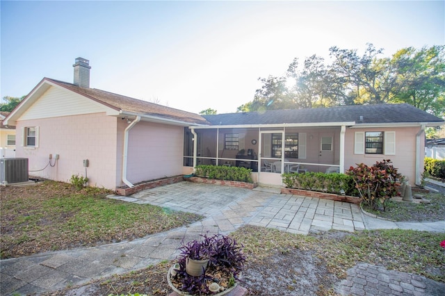 613 Andrew St, Altamonte Springs, FL 32714 - back of house featuring a sunroom, a chimney, central AC unit, and roof with shingles