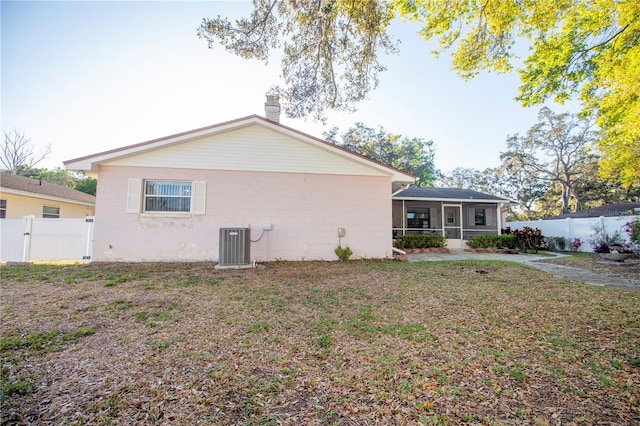 613 Andrew St, Altamonte Springs, FL 32714 - back of house with a sunroom, concrete block siding, a chimney, and central AC unit