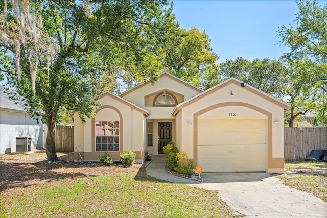 mediterranean / spanish house featuring stucco siding, driveway, a garage, and fence