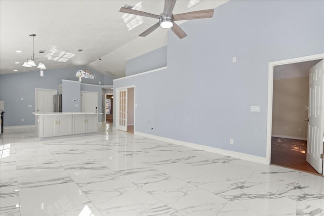 unfurnished living room with baseboards, marble finish floor, and high vaulted ceiling