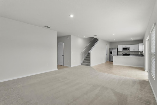 1506 Finnigan Cir, Haines City, FL 33844 - unfurnished living room featuring visible vents, light carpet, recessed lighting, light tile patterned floors, and stairs