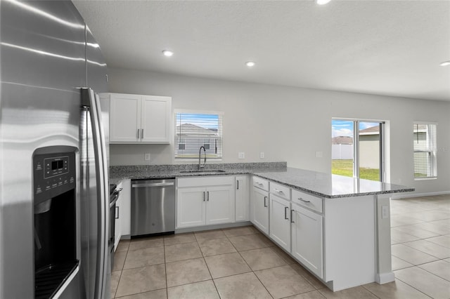 1506 Finnigan Cir, Haines City, FL 33844 - kitchen featuring a sink, light stone counters, white cabinetry, stainless steel appliances, and a peninsula