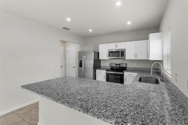 1506 Finnigan Cir, Haines City, FL 33844 - kitchen with light stone countertops, visible vents, a peninsula, a sink, and appliances with stainless steel finishes