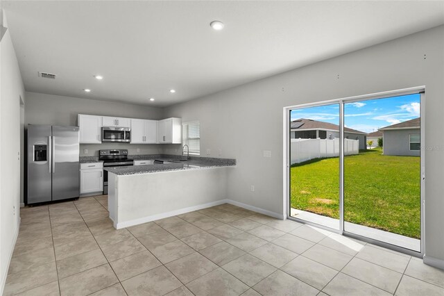 1506 Finnigan Cir, Haines City, FL 33844 - kitchen featuring a sink, white cabinetry, recessed lighting, appliances with stainless steel finishes, and a peninsula