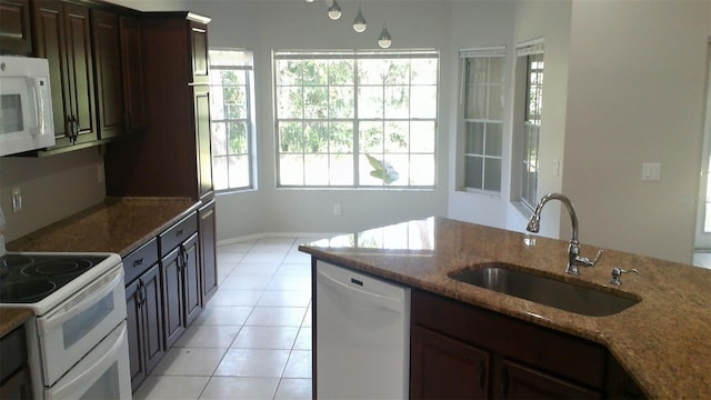 1760 Imperial Palm Dr, Apopka, FL 32712 - kitchen featuring white appliances, dark brown cabinets, a sink, stone counters, and light tile patterned floors
