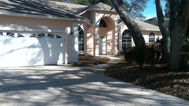 1760 Imperial Palm Dr, Apopka, FL 32712 - view of home's exterior featuring stucco siding, driveway, a garage, and roof with shingles