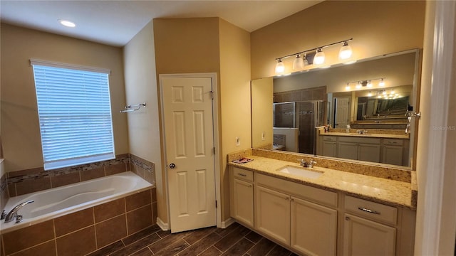 2749 Sand Oak Loop, Apopka, FL 32712 - bathroom featuring a stall shower, a garden tub, two vanities, and wood finished floors