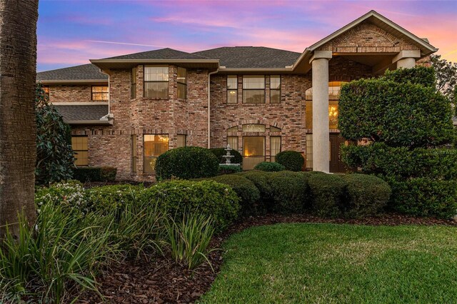 132 Pleasant Valley Dr, Daytona Beach, FL 32114 - view of front facade with brick siding, roof with shingles, and a lawn
