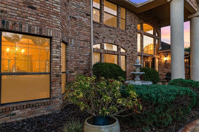 132 Pleasant Valley Dr, Daytona Beach, FL 32114 - exterior entry at dusk featuring brick siding